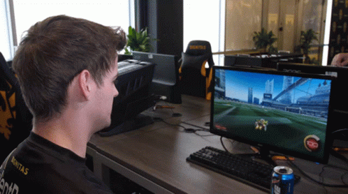 a boy sitting at a computer playing a game