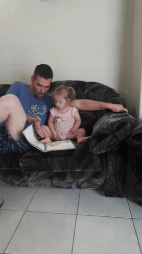 a man with a baby laying on a couch