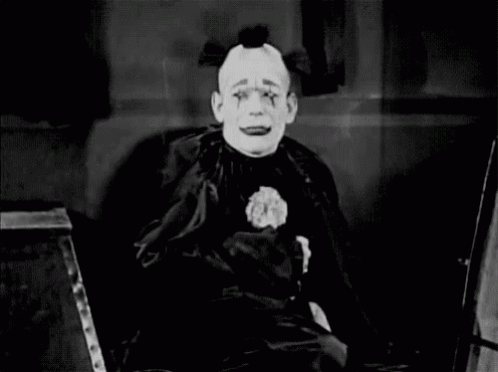 a creepy clown sitting in front of an instrument