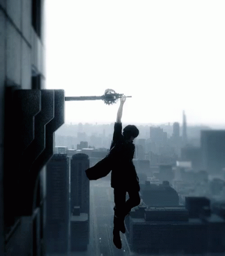 a man holding a guitar while standing on top of a building