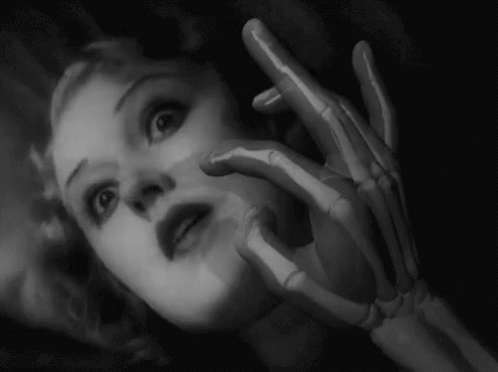 a woman with skeleton hands next to her face