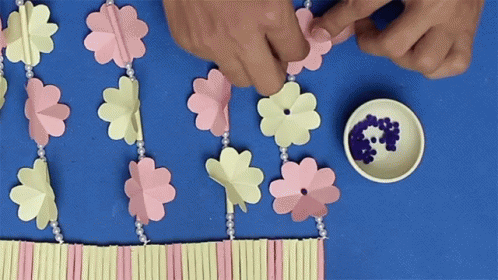 the two hands are making flower decorations together