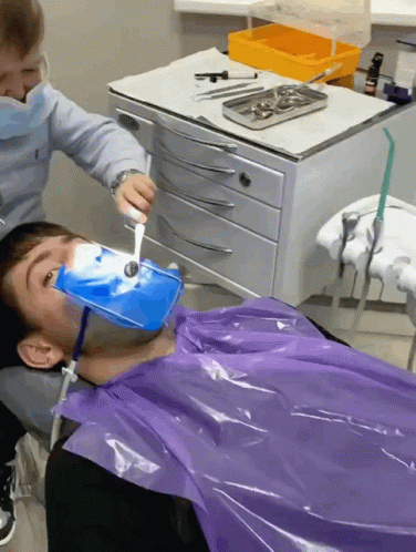 an image of a dentist holding soing in his mouth