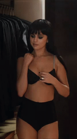 a young lady dressed in black lingerie and holding a cellphone
