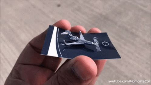 a person holding a tiny plane piece that they are holding