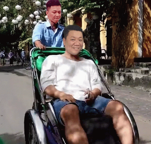 a man in a wheelchair is smiling at another guy
