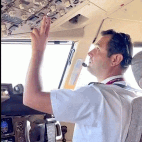 a man standing in the middle of an airplane with a remote in his hand