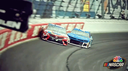 two racing cars at the turn in front of an appliance on the television