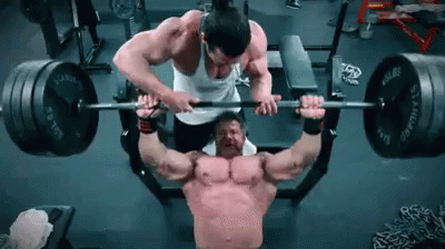 man lifting barbells on his chest as another mans prepares to squat down