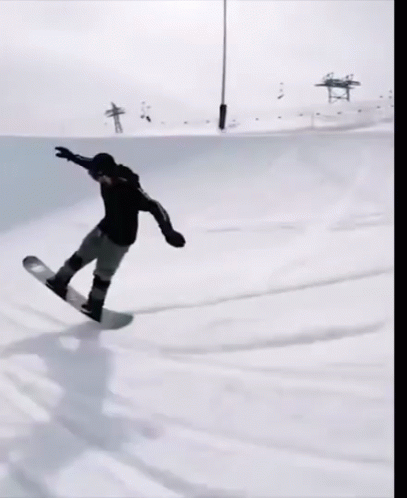 a snowboarder is riding a rail at a ski slope