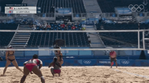 a beach volleyball game is being played by some athletes