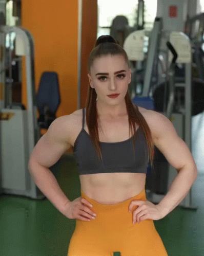 a young woman posing in a gym with the camera reflected in her eye