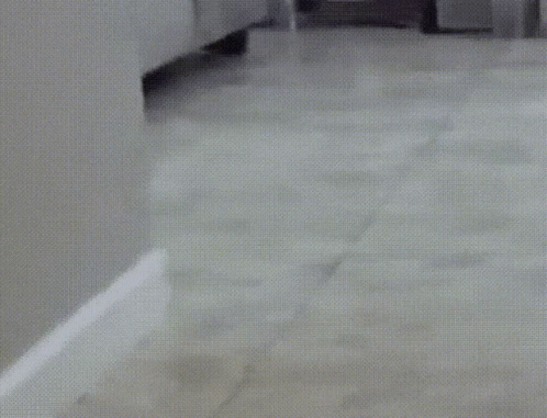 the floor in a bathroom with a white toilet and cabinets