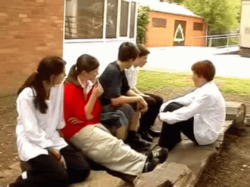 several people sitting on a bench near each other