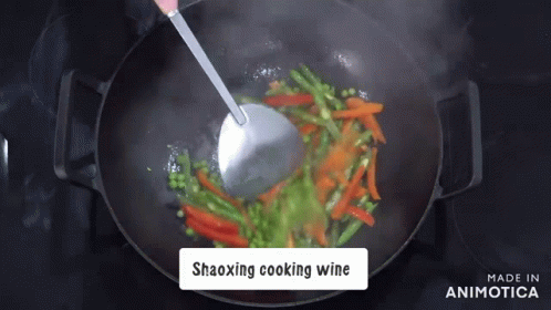 a person cooking on an oven with blue and green vegetables