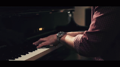 a person is playing a piano in the dark