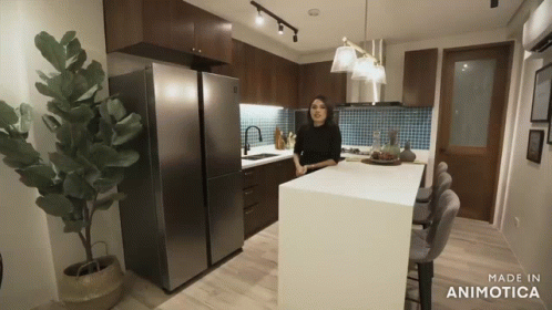 a woman standing in the middle of an open kitchen