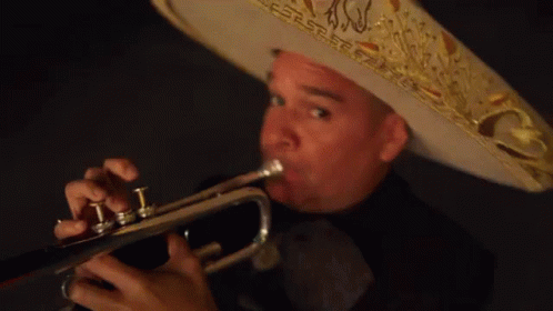 a man with blue hair wearing a mexican hat while playing the trumpet