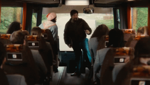 two people stand in the middle of a bus