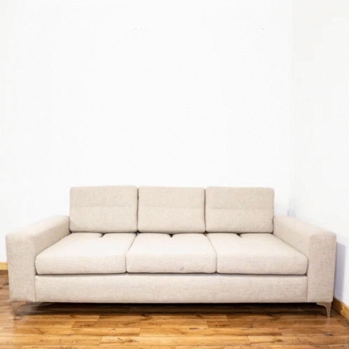 a couch sits on the floor in front of a wall