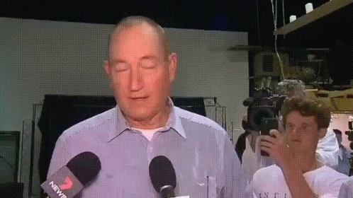 a man is speaking in front of microphones