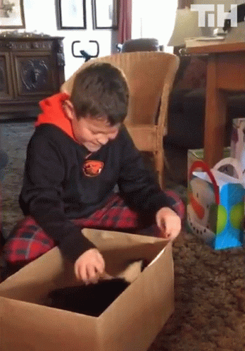 a child sitting in a box playing with a toy