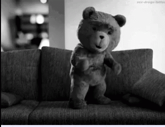 a black and white po of a teddy bear on a couch