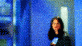 blurry image of person walking in hallway with cellphone