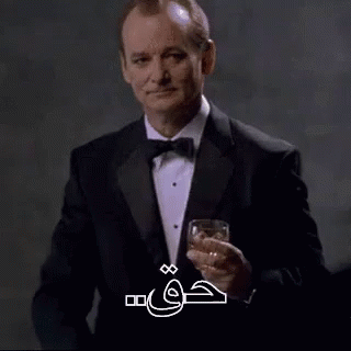 an image of a man in suit and tie holding a drink