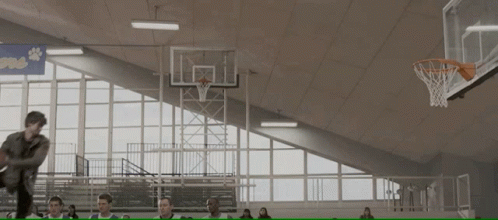 a man is jumping in the air to dunk his basketball