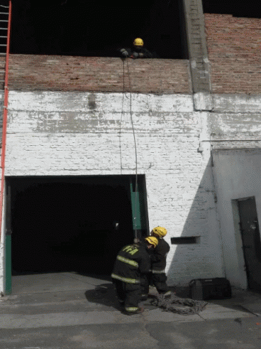 two firemen in front of a white building