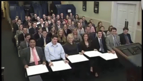 a large group of people behind a row of desks