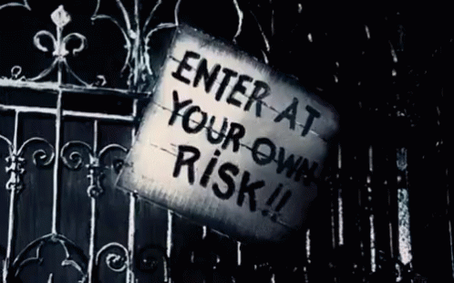 a metal fence has a sign attached to it that says enter at your own risk