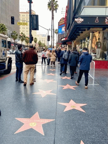 an image of people walking near many stars