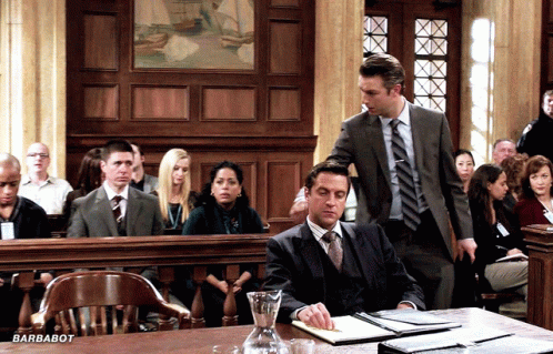 some people in a courtroom with one man wearing a suit and tie