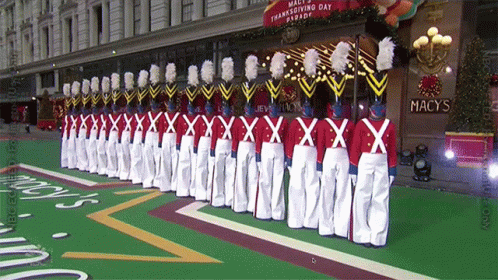 a parade with marching men in white uniforms
