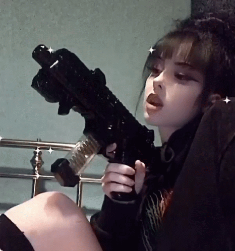 a woman sitting on a bed holding a gun