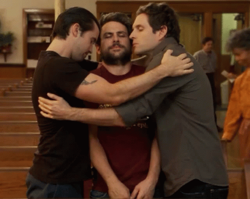 a group of young men hugging each other in the room