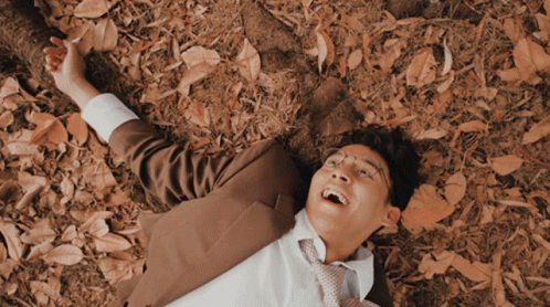 a man is lying on the ground in a suit and tie