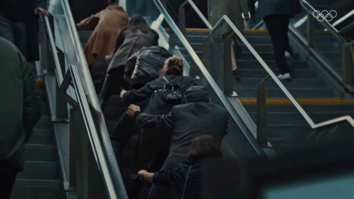 people walking down some stairs carrying luggage