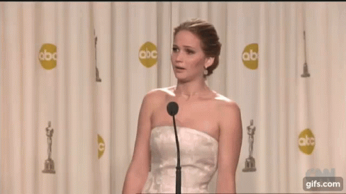 the woman wearing a white dress is giving her speech at an awards event