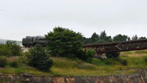 a train is going over a bridge, during the day