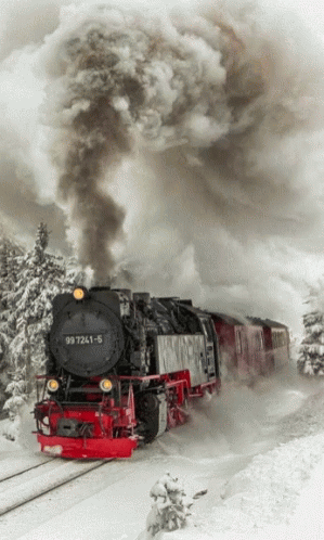 steam is blowing from the top of a train as it travels through snow