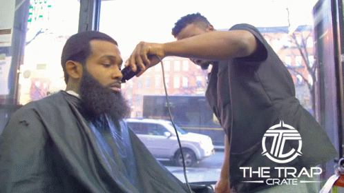 a man having his hair cut by another mans head