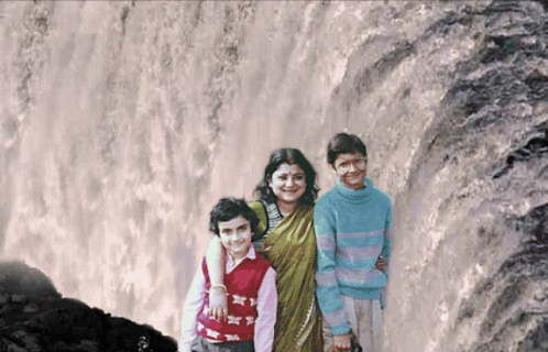 the family poses for a pograph in front of a waterfall