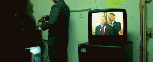 there is a television sitting next to a stand with a man