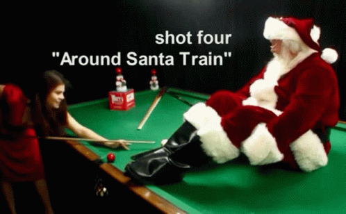 a man dressed as santa claus sitting on a pool table