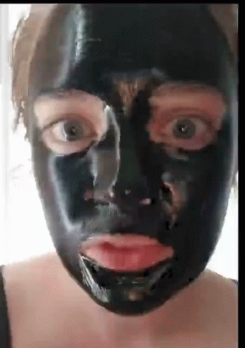 a woman wearing black mask and looking into camera