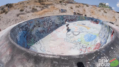 a skateboard ramp in a concrete area with graffiti on the walls and the ground