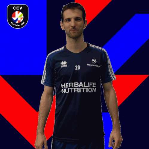 a man in black soccer uniform standing against red and blue background
